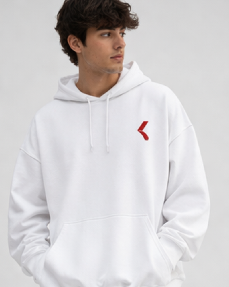 man wearing white oversized hoodie with KRPA logo on the left side standing on a light background 