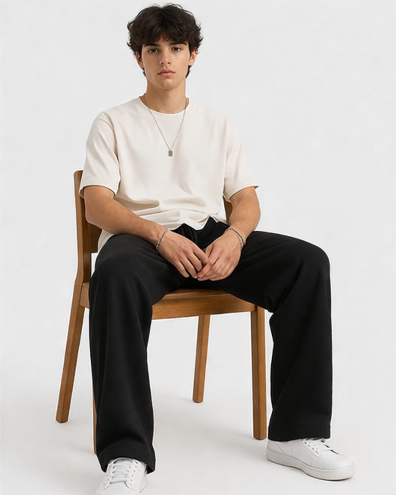 man wearing KRPA sweat pant sitting on a chair confidently on a plain background 