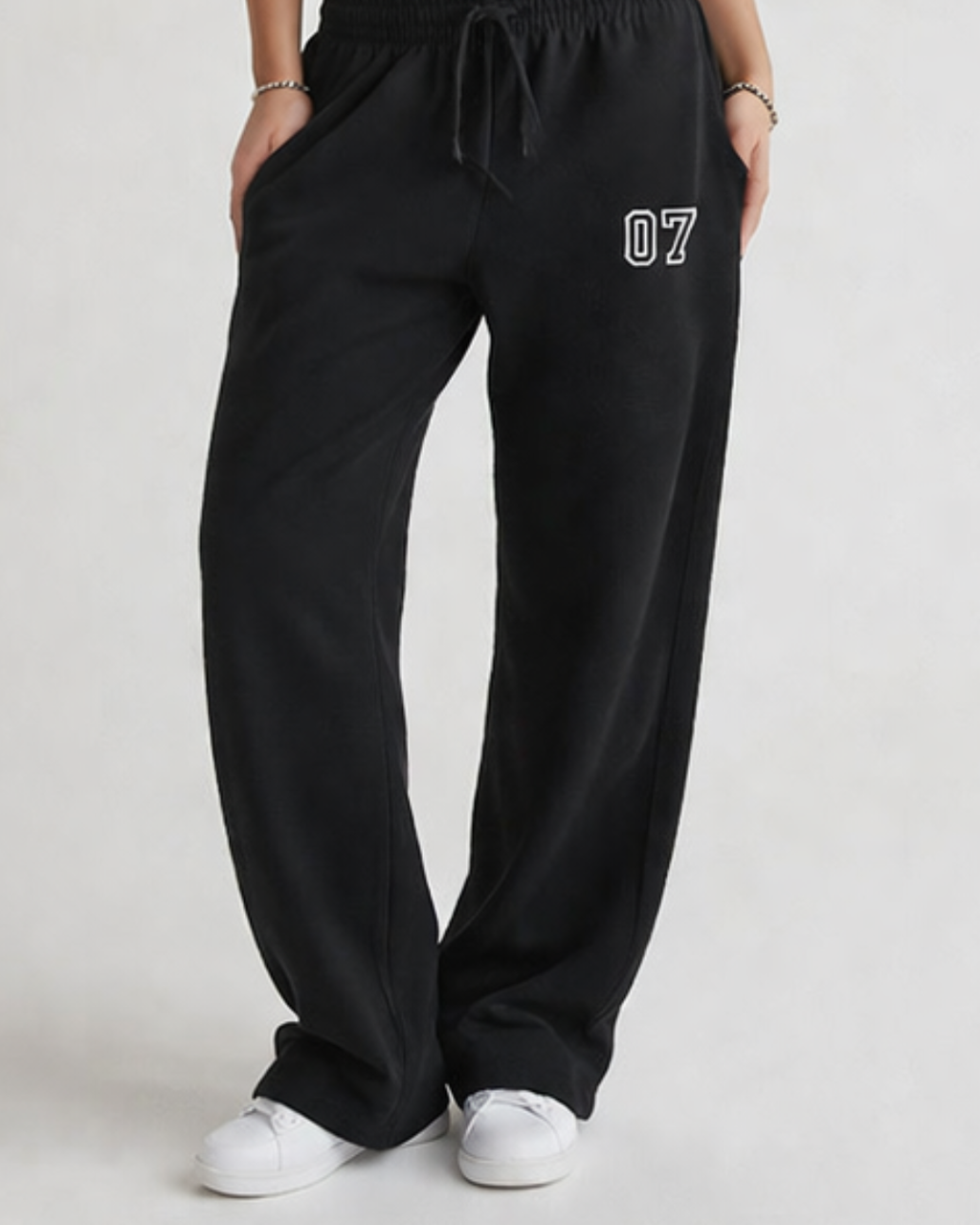 Person wearing black sweatpants with a number '07' on a light gray background