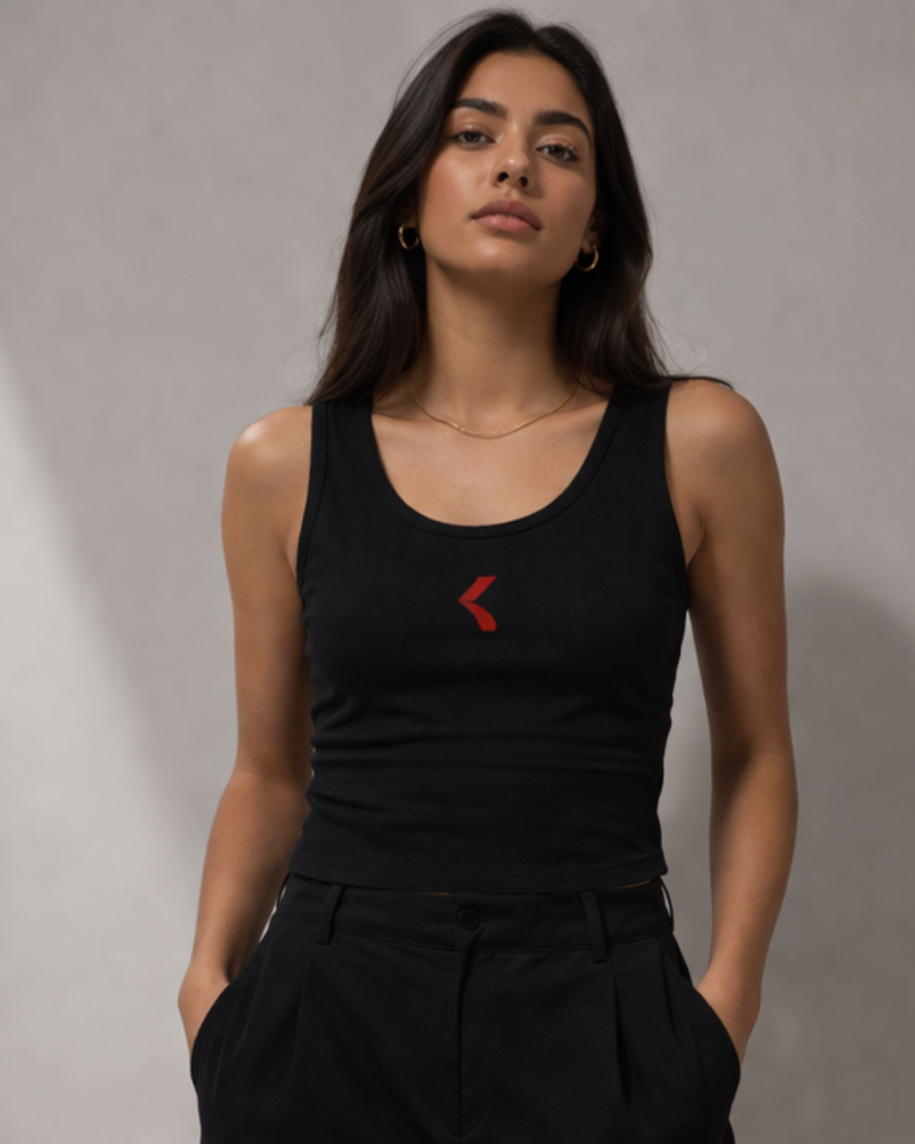 Woman wearing a black tank top with krpa logo against a gray background