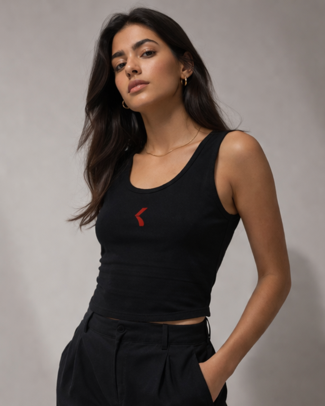 Woman wearing a black tank top with krpa logo against a plain background