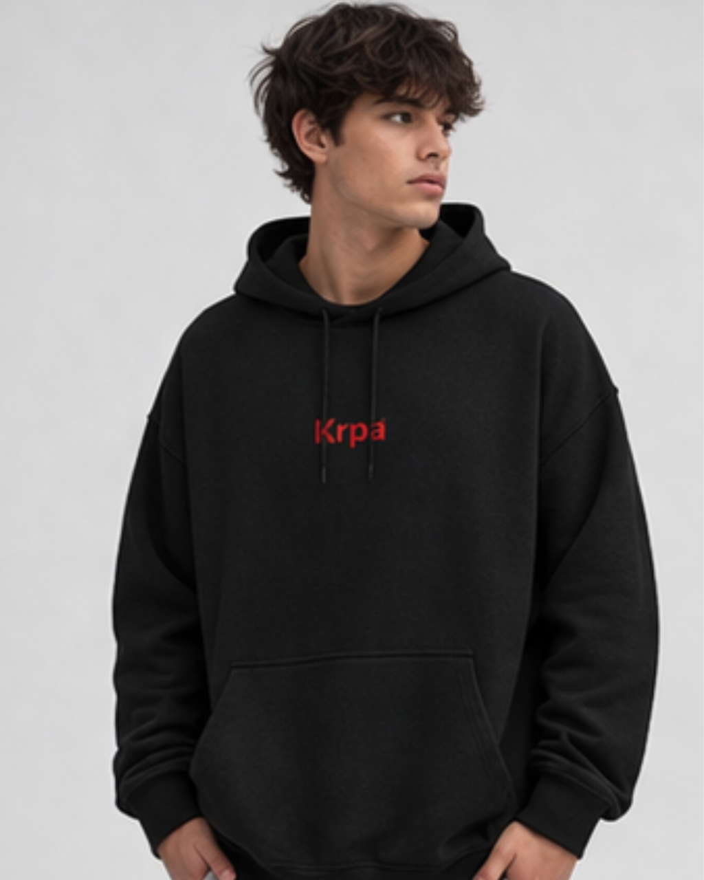 Person wearing a black hoodie with KRPA logo on a light gray background