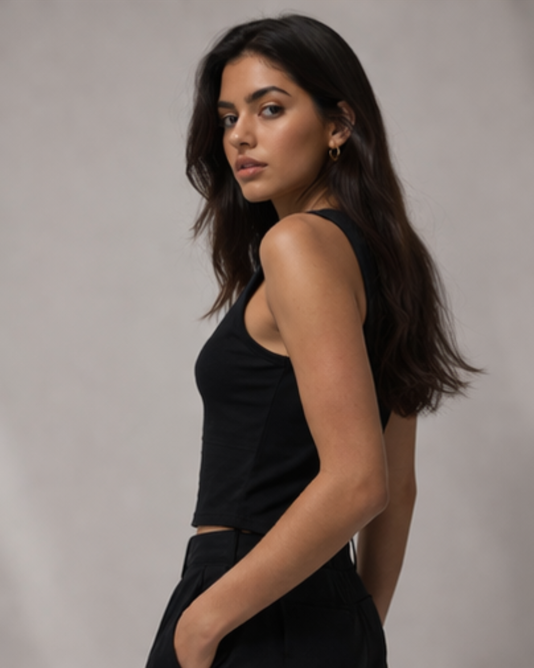 woman wearing krpa branded black tank top standing in a light background 