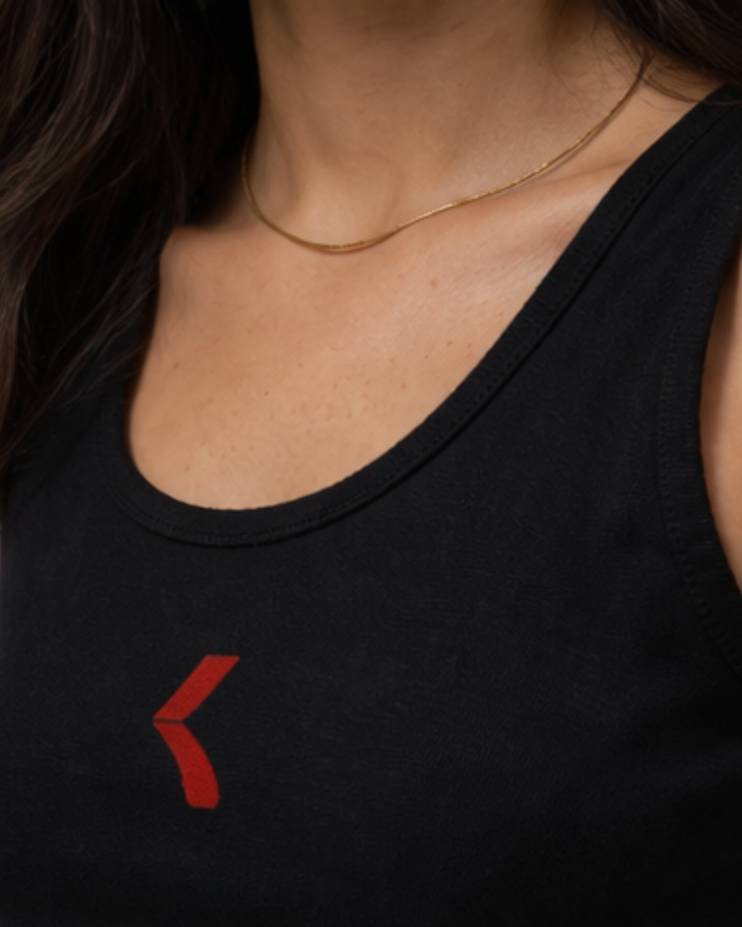 close-up of a woman wearing black tank top focusing on the neckline and krpa logo styled with minimal neck chain for a clean and elegant look 