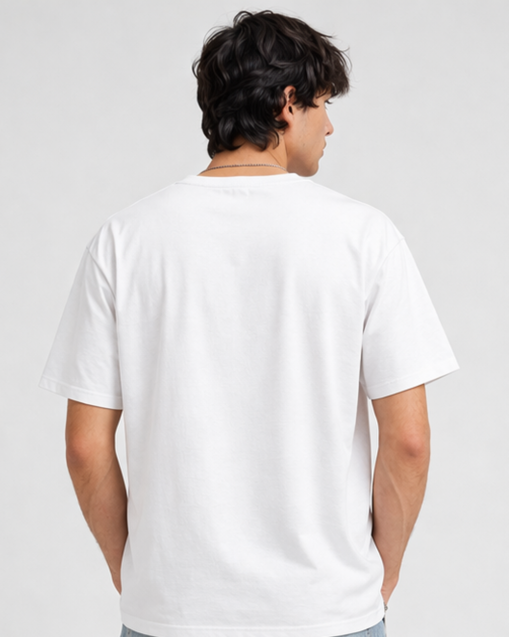 Person wearing a plain white t-shirt on a light gray background
