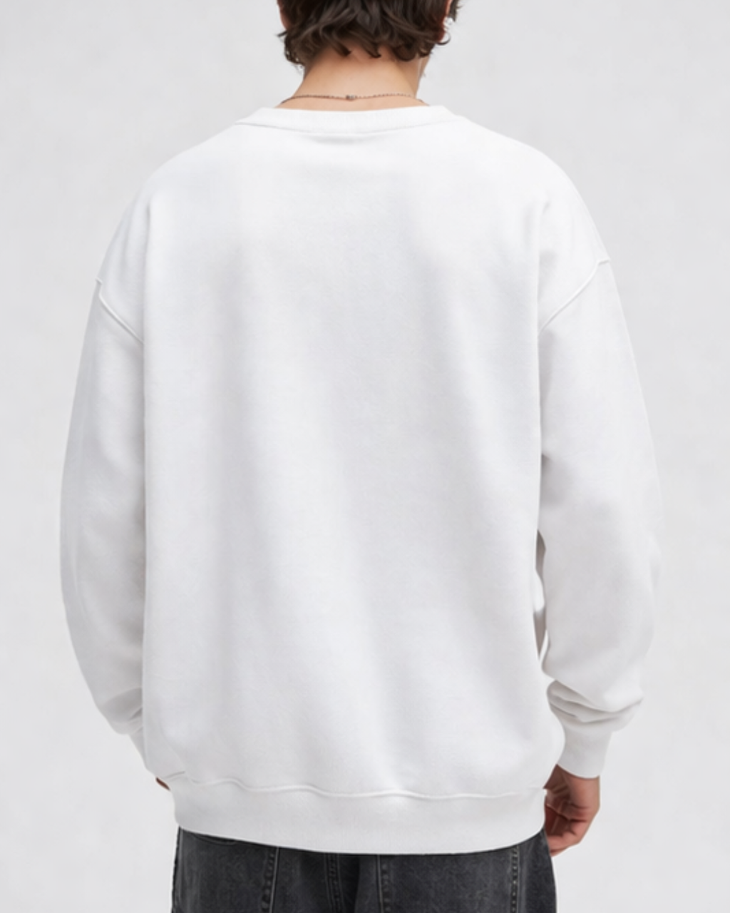 Person wearing a plain white sweatshirt on a light gray background