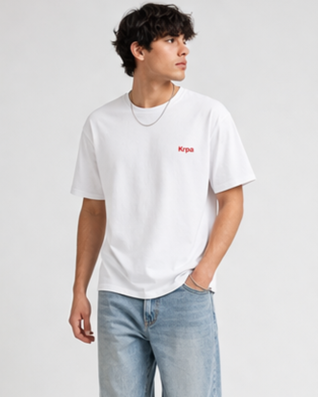 Person wearing a white t-shirt with a krpa logo on a plain background