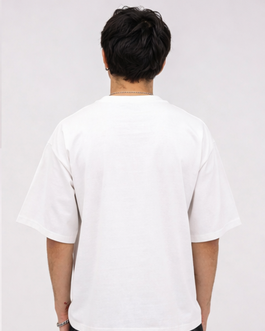 Person wearing a plain white t-shirt against a light gray background