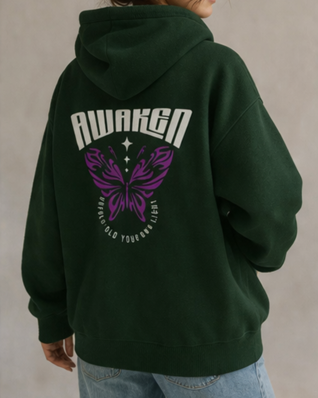 Green hoodie with 'Awaken' and butterfly design on the back, worn by a person.