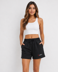 Woman wearing a white crop top and black shorts with KRPA logo on a plain background