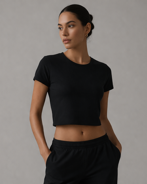 Woman wearing a black t-shirt and black pants against a gray background