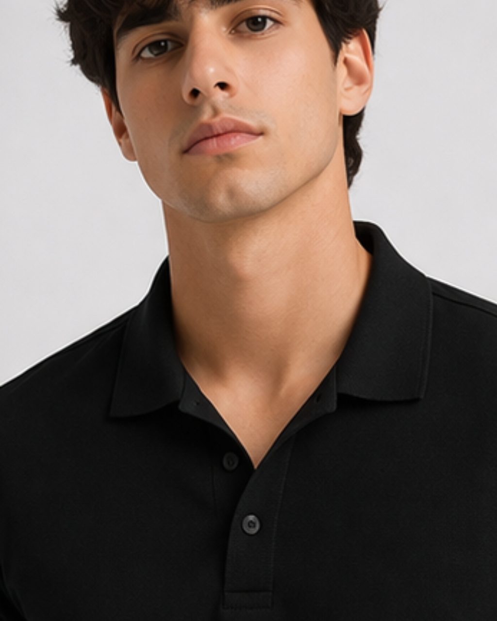 Man wearing a black polo t-shirt against a plain background