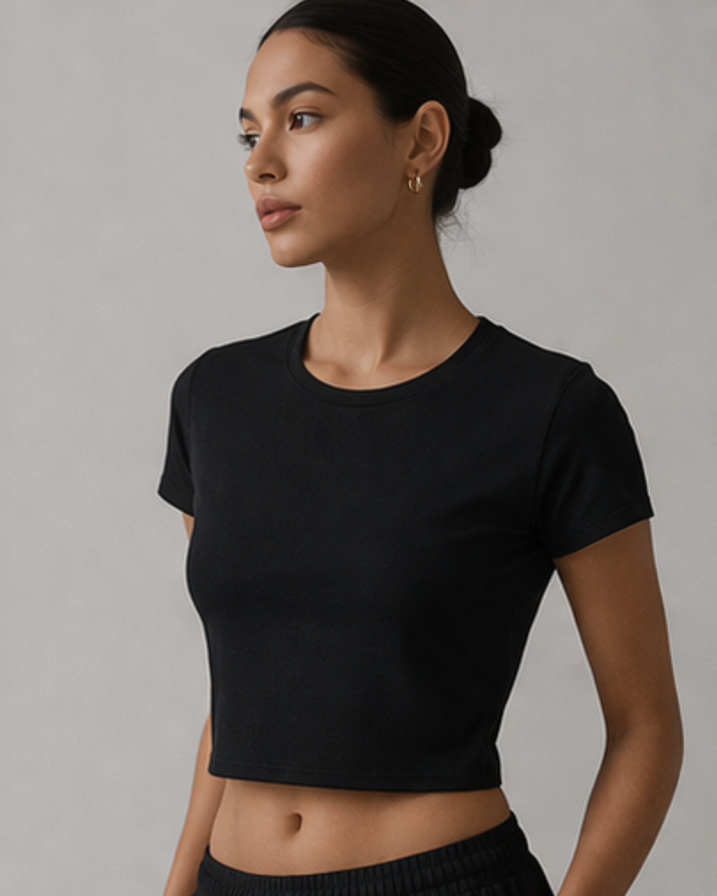 Woman wearing a black crop top against a neutral background