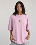 Woman wearing a light pink oversized t-shirt with 'Blah' written in the middle on a plain background