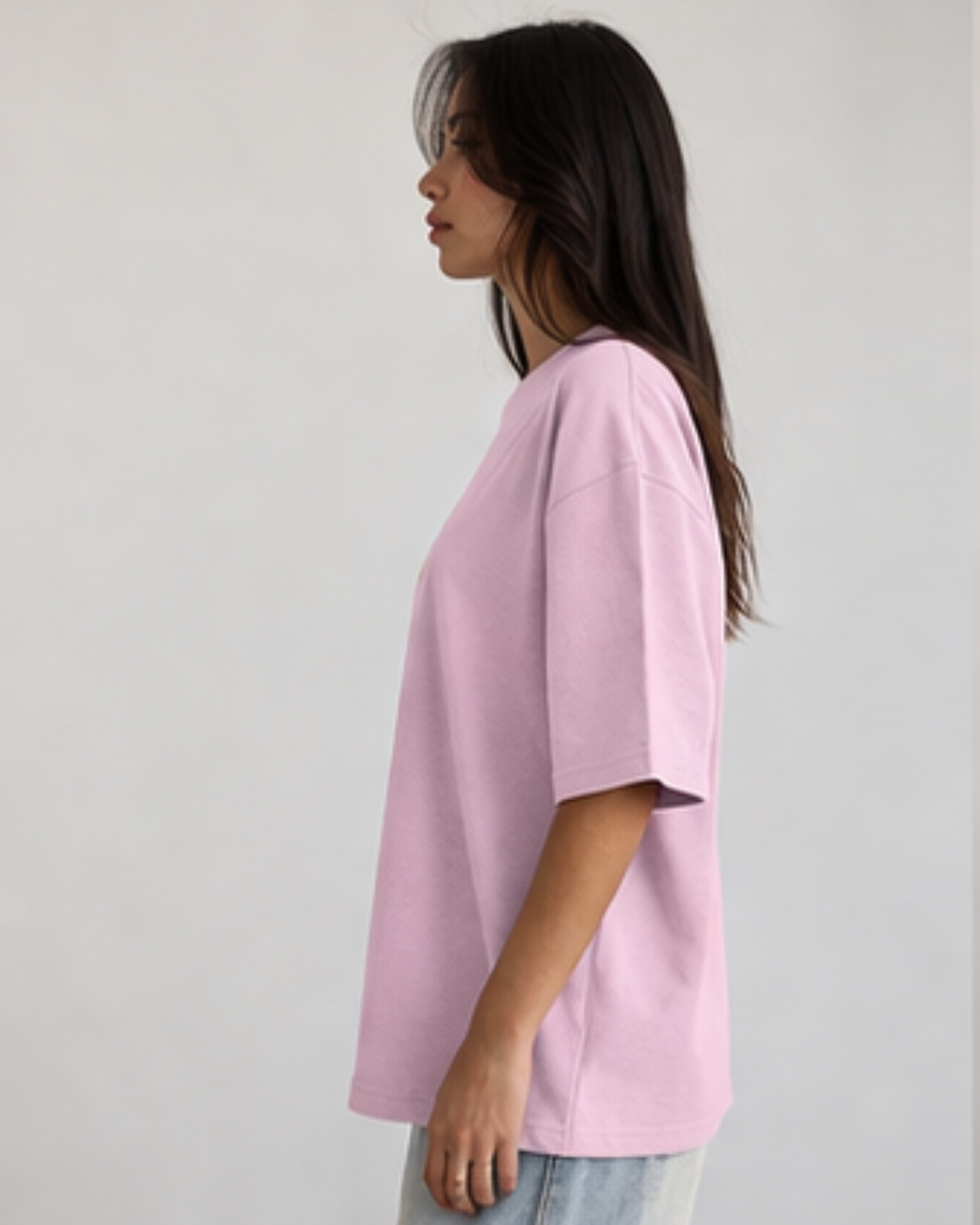 Person wearing a light pink oversized t-shirt against a plain background