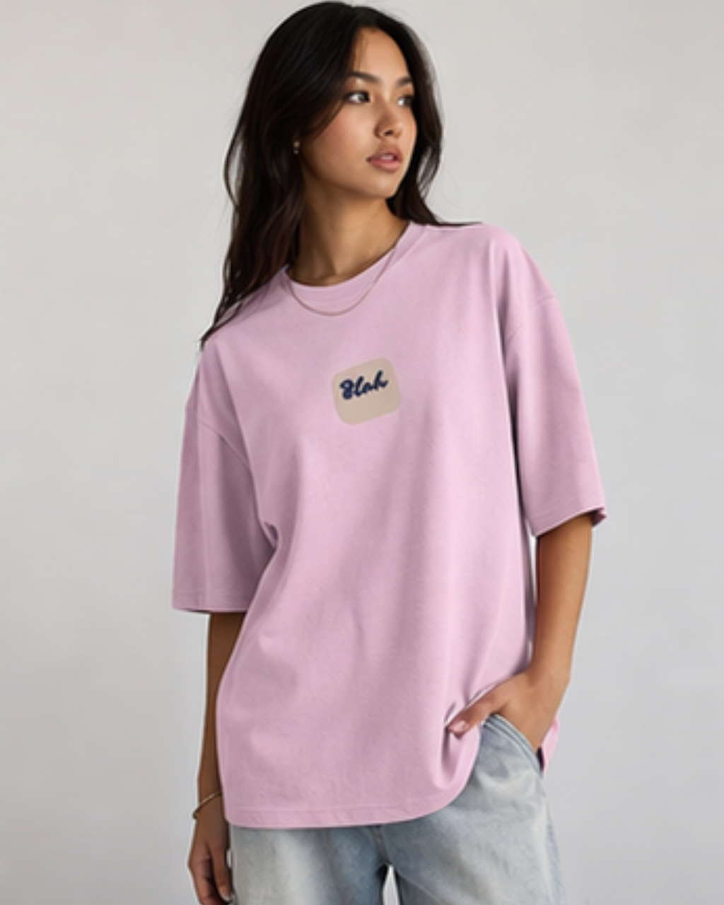 Woman wearing a pink t-shirt with a 'Blah' written in the middle on a plain background