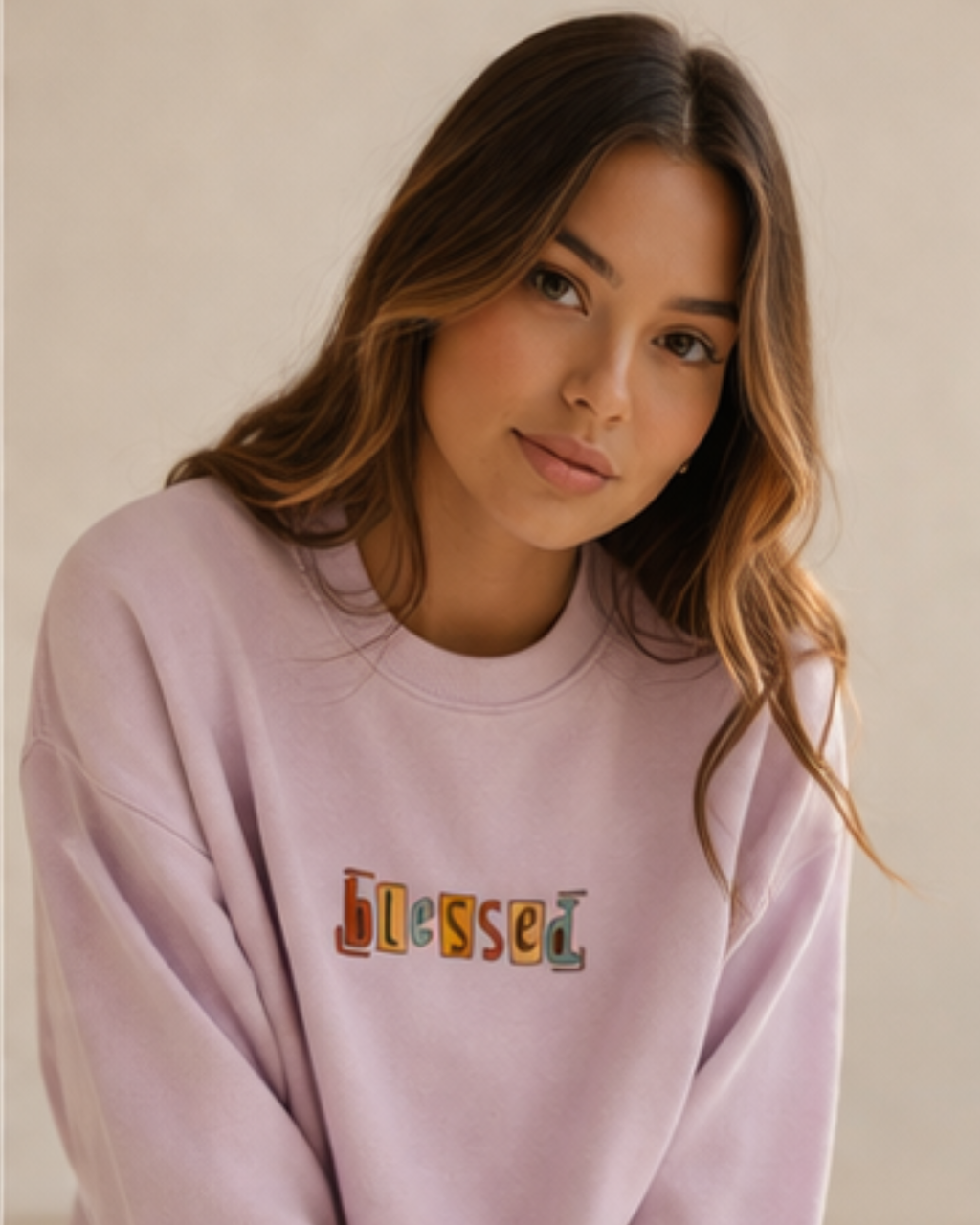 Woman wearing a pink sweatshirt with 'blessed' text on a plain background