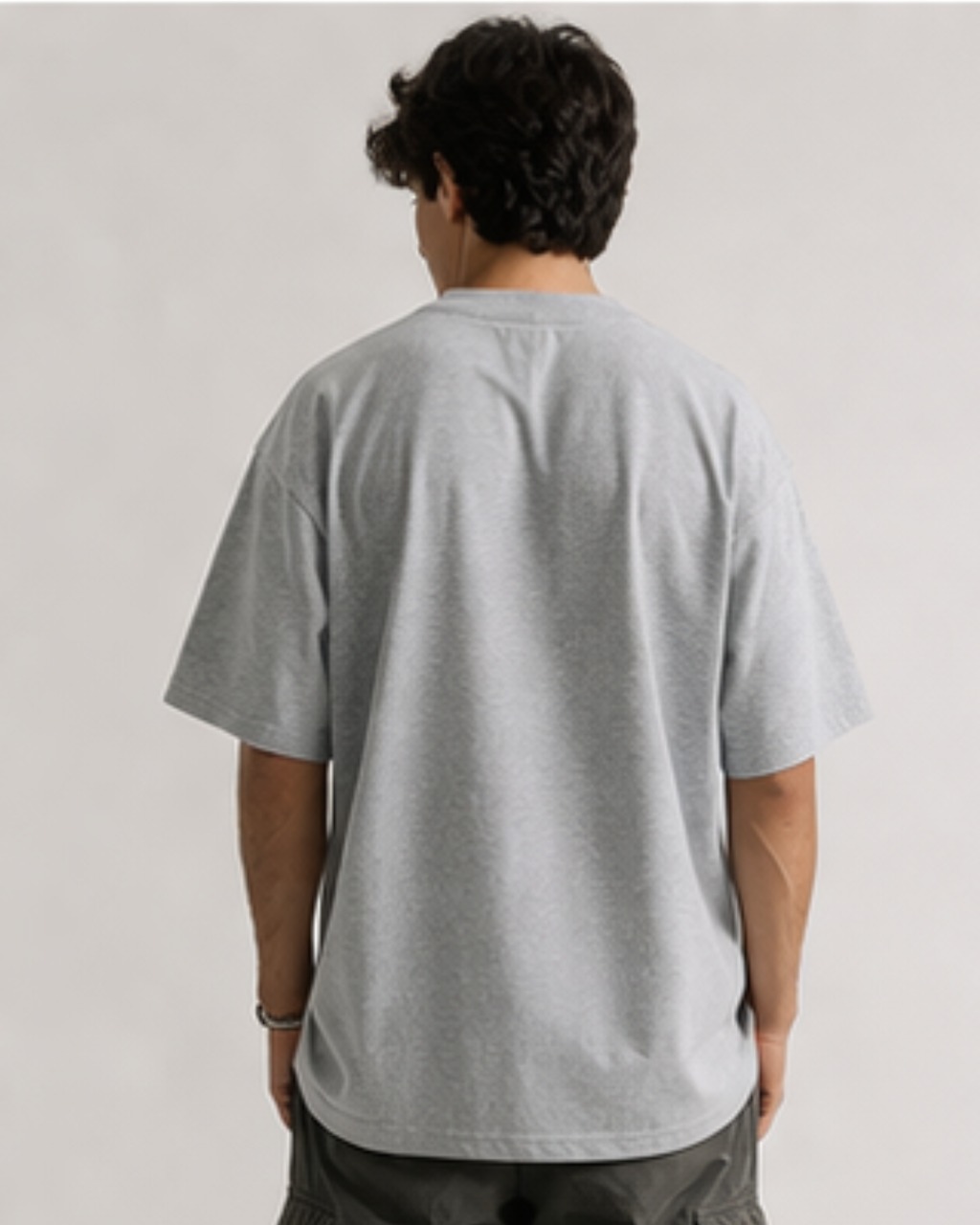 Person wearing a gray t-shirt on a plain background
