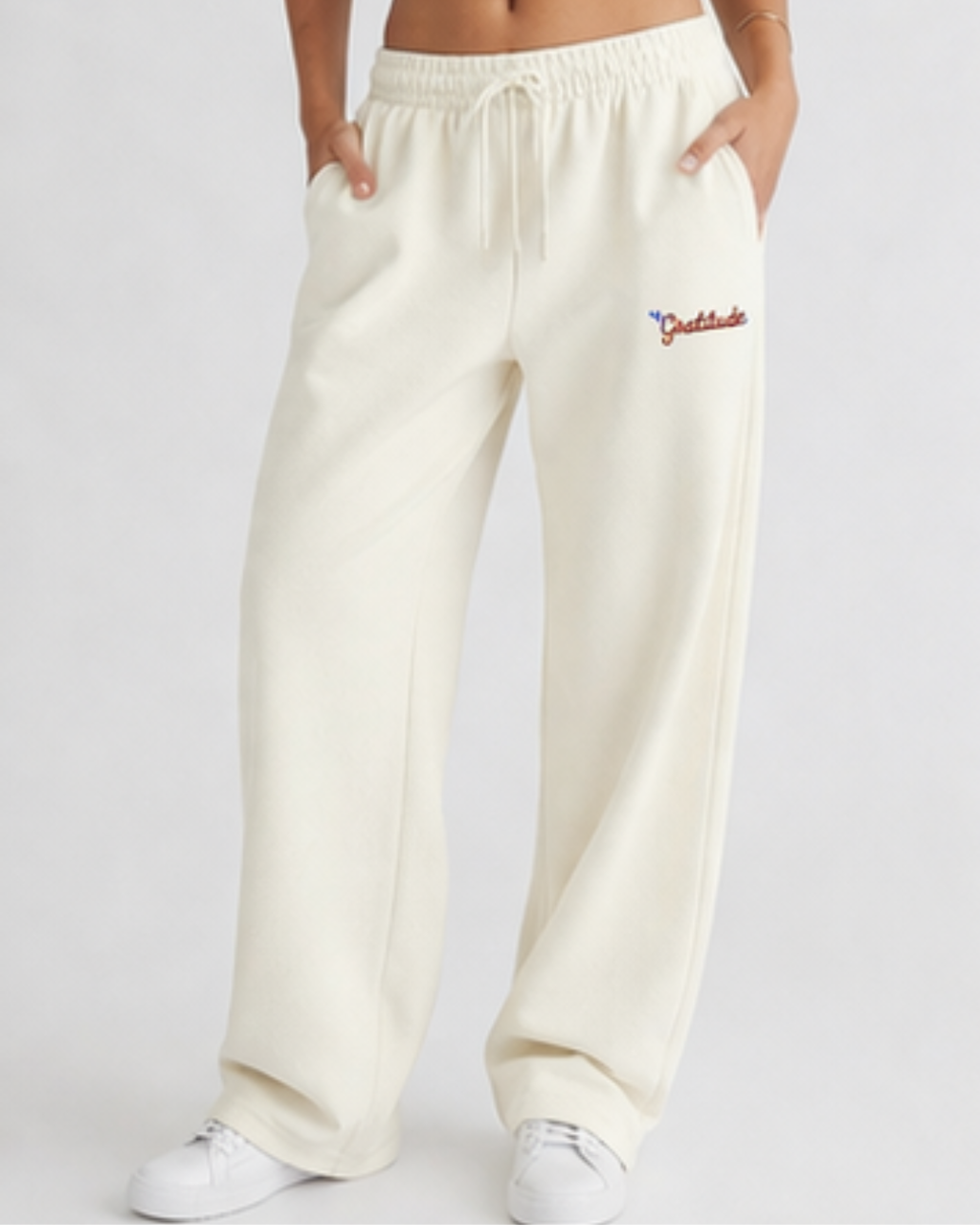 White sweatpants with gratitude written on a white background