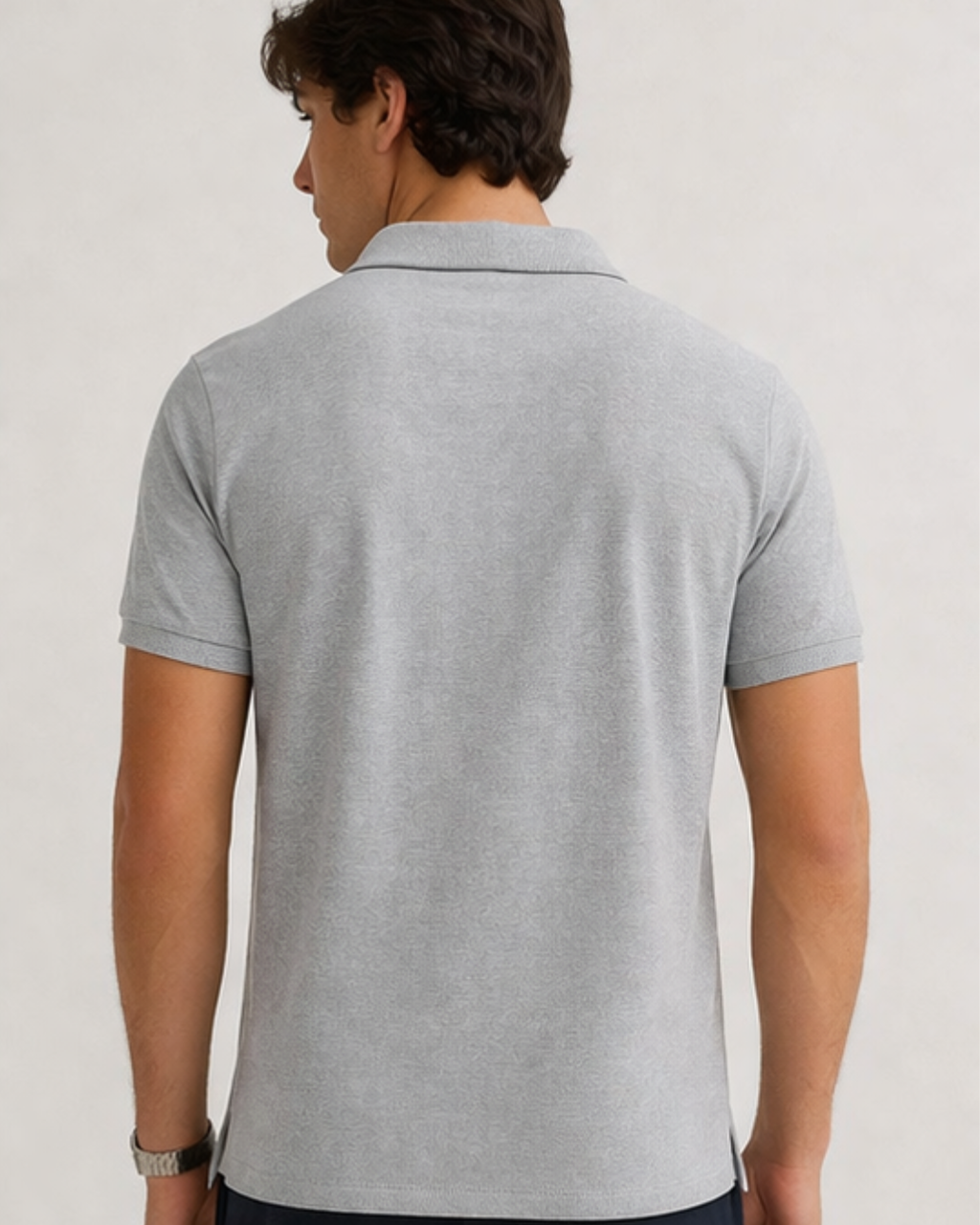 Person wearing a gray polo shirt against a plain background