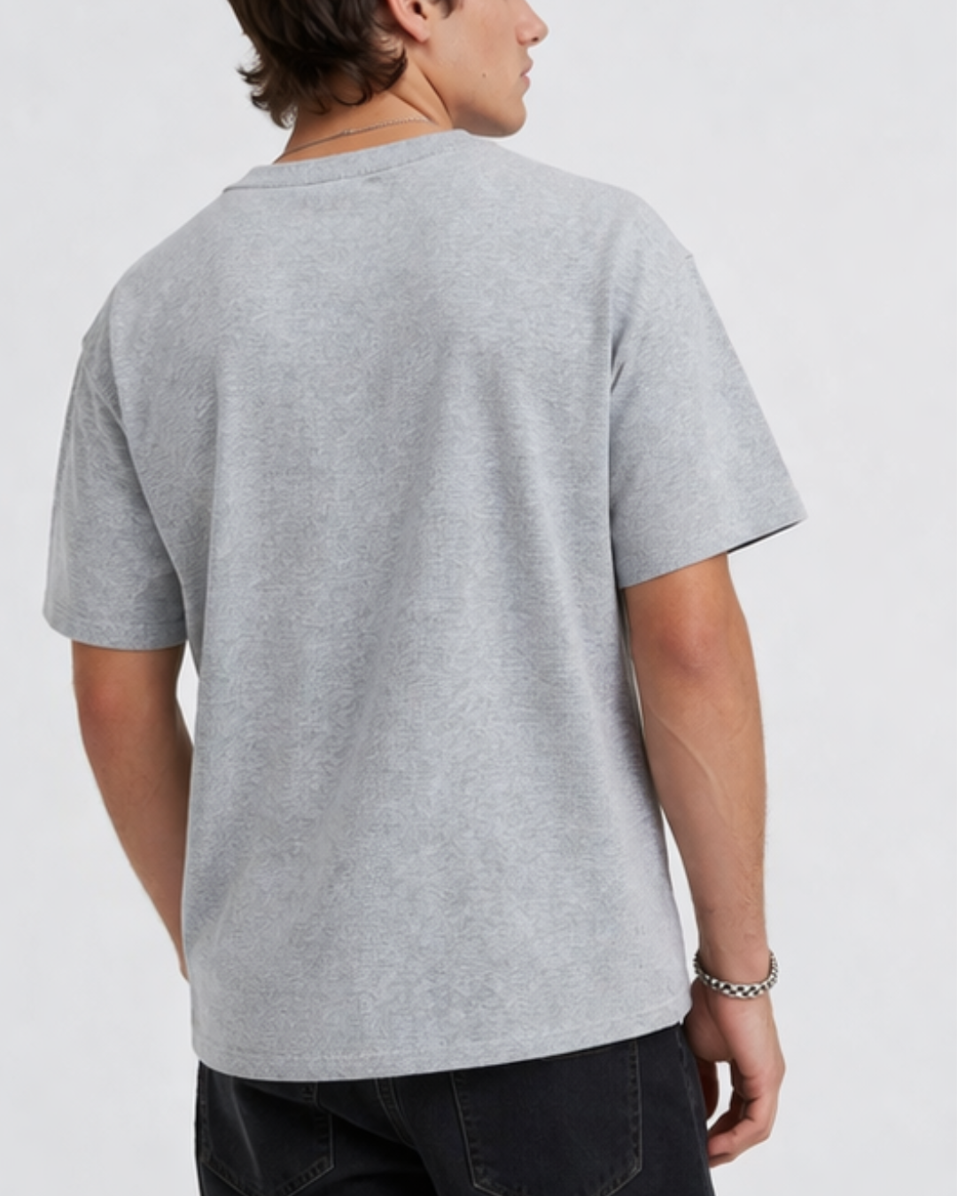 Person wearing a gray t-shirt on a plain background