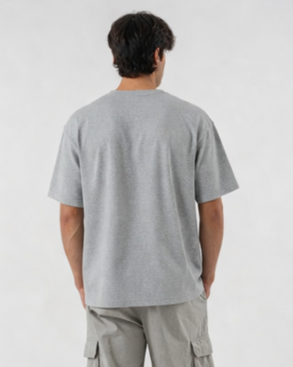 Person wearing a gray t-shirt and cargo pants on a white background