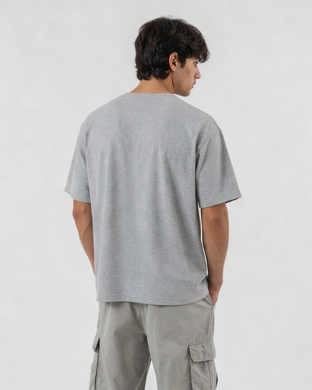 Person wearing a gray t-shirt and cargo pants on a white background