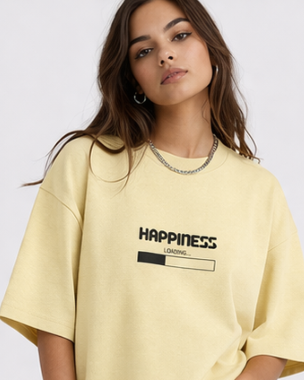 Woman wearing a yellow oversized t-shirt with 'Happiness Loading' text on a white background