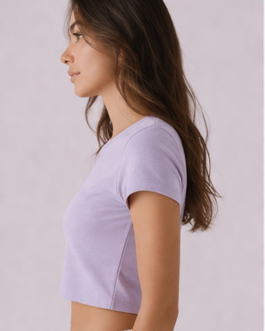 Woman wearing a light purple t-shirt against a plain background