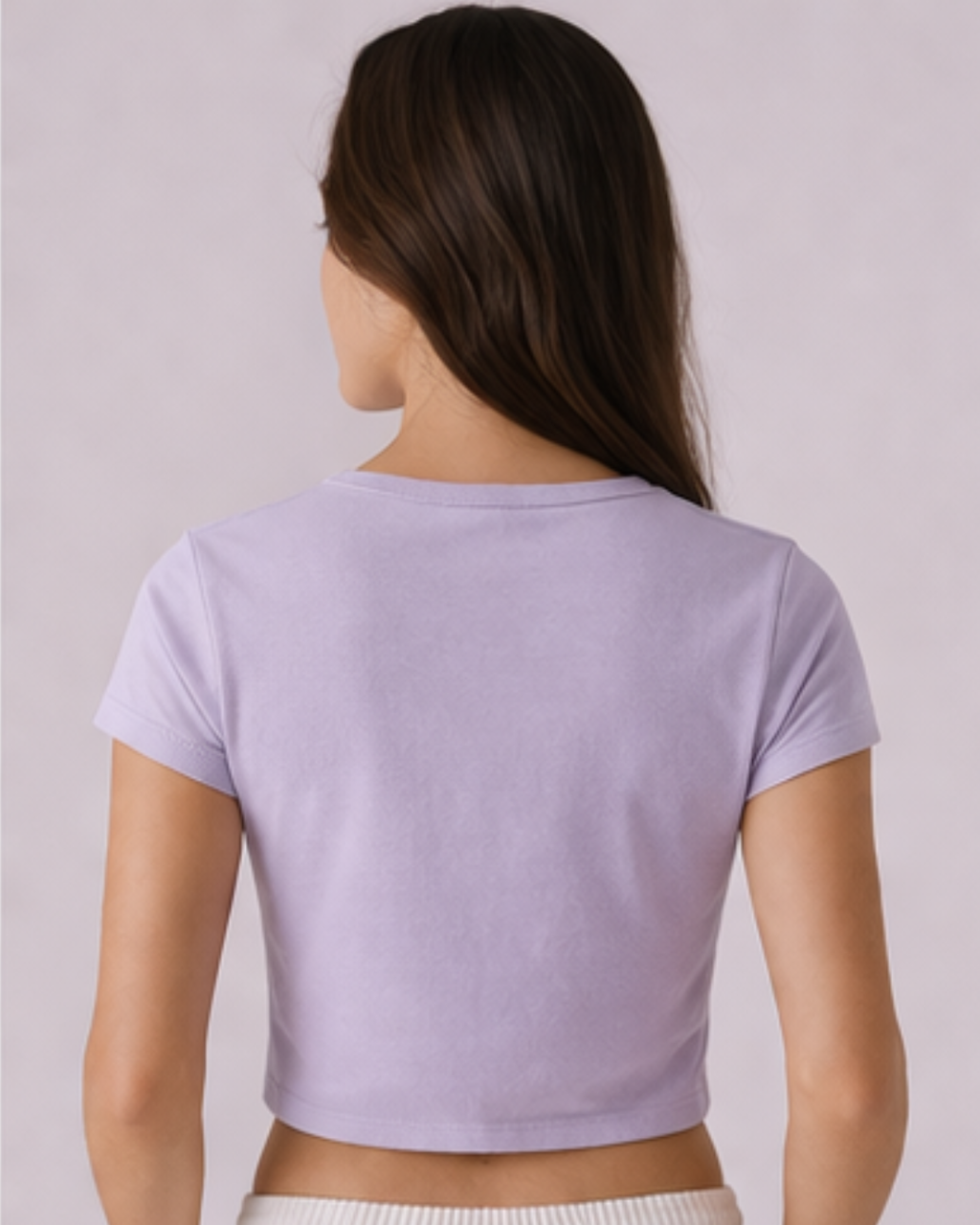 Person wearing a light purple cropped t-shirt against a plain background