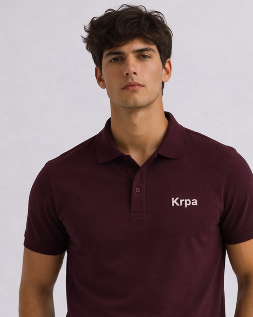 Man wearing a maroon polo shirt with 'Krpa' logo on a light gray background