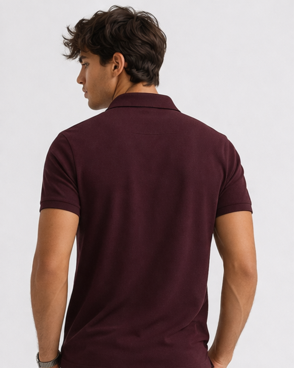 Man wearing a maroon polo shirt on a light gray background