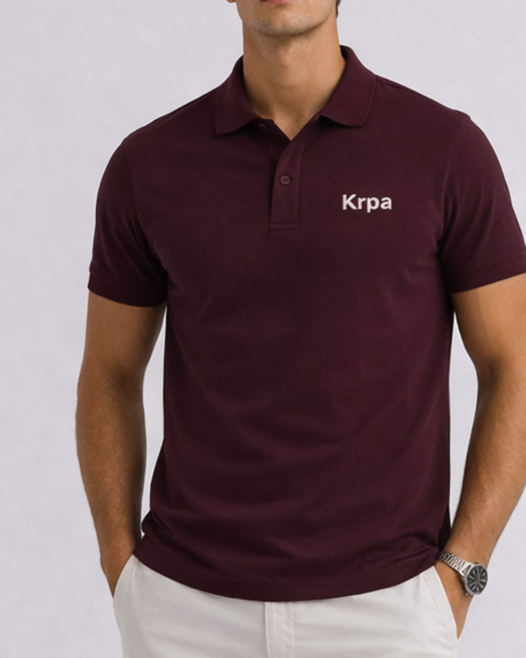 Man wearing a maroon polo shirt with 'Krpa' logo on a light gray background
