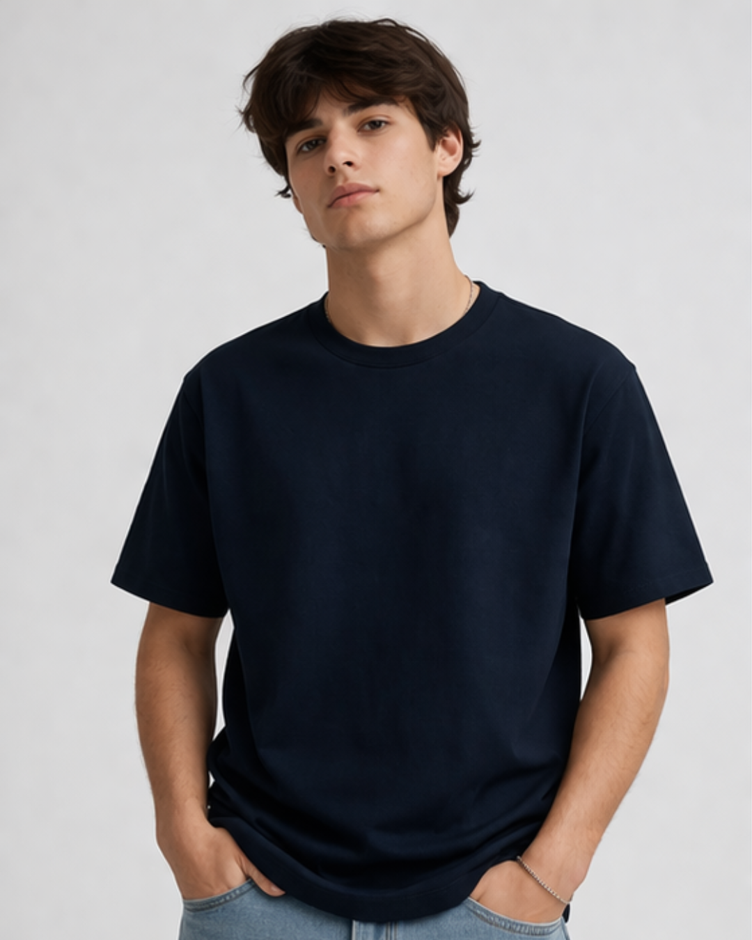 Person wearing a plain navy blue t-shirt against a light gray background