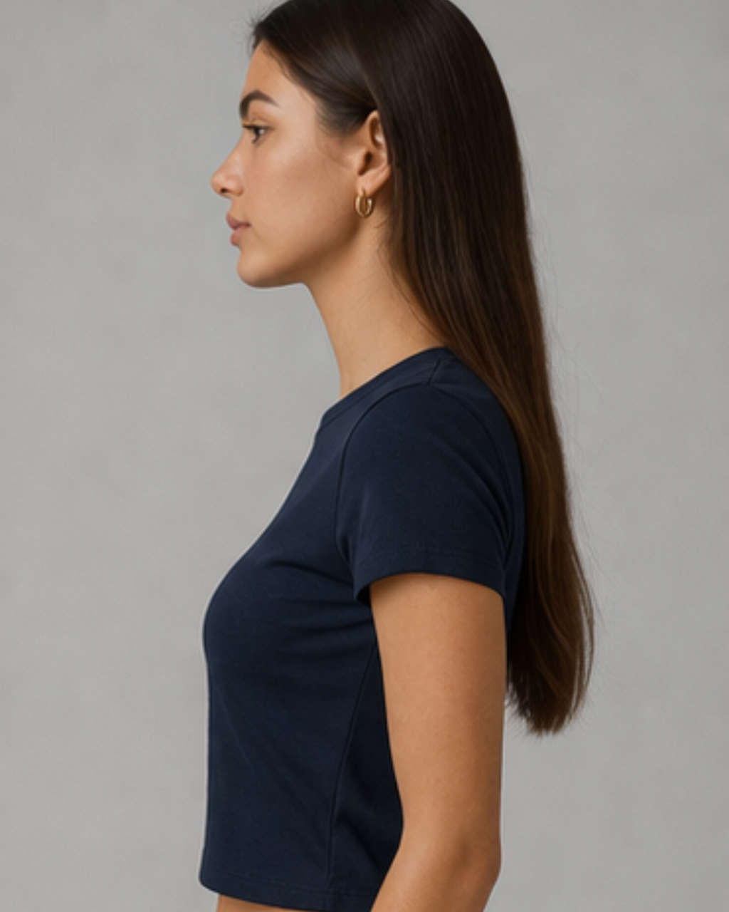 Woman wearing a navy blue t-shirt against a gray background