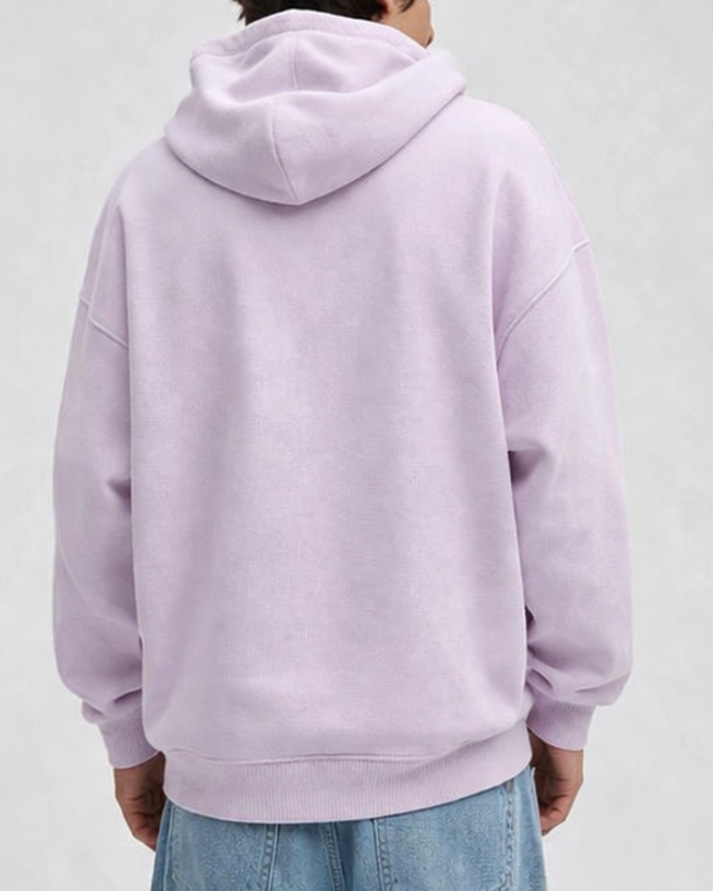 Person wearing a baby pink hoodie on a plain background