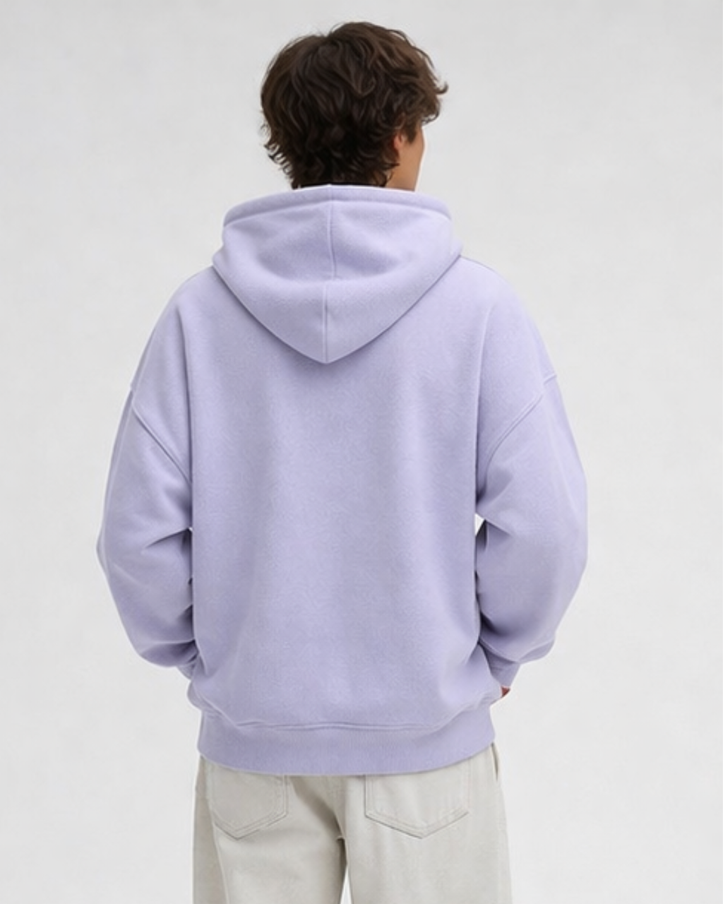Person wearing a light purple hoodie on a plain background