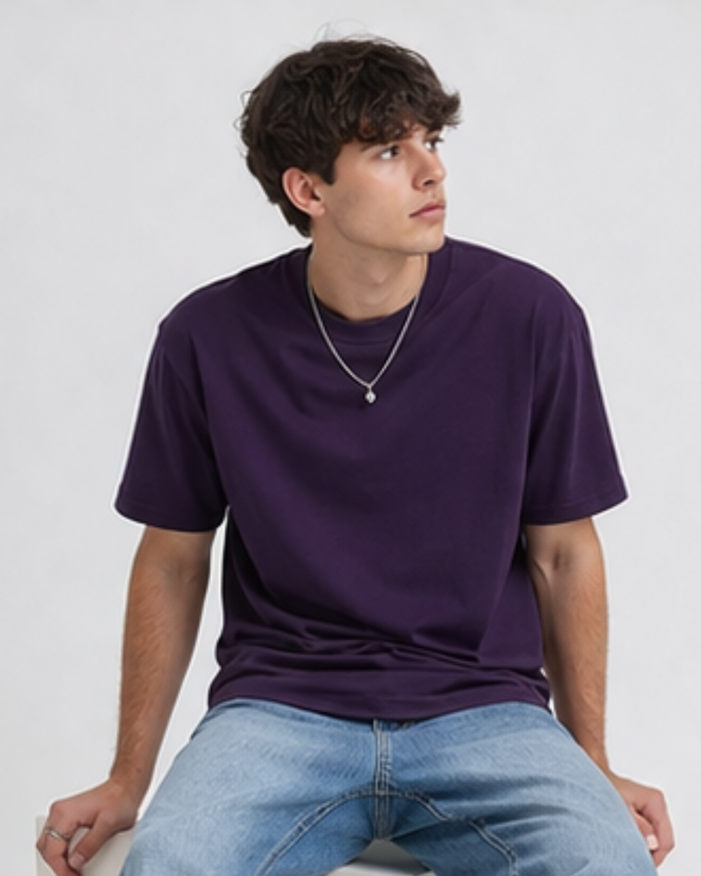 Person wearing a purple t-shirt and blue jeans against a white background