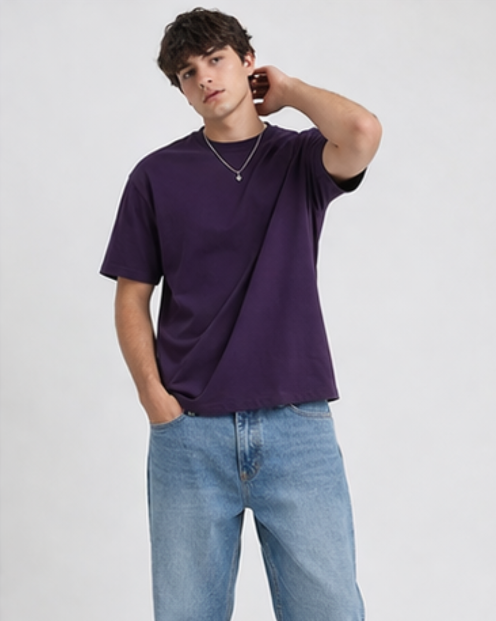 Man wearing a purple t-shirt and blue jeans on a white background