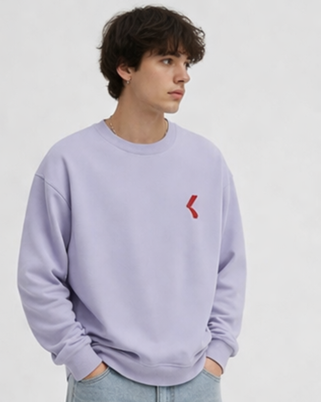 Person wearing a light purple sweatshirt with a red logo on a plain background