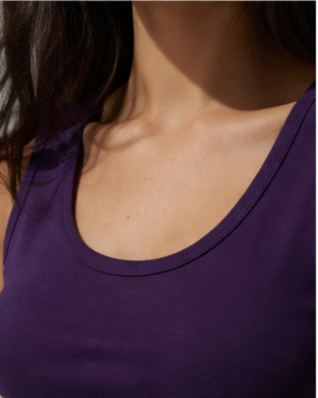 Close-up of a person wearing a purple tank top with a focus on the neckline.