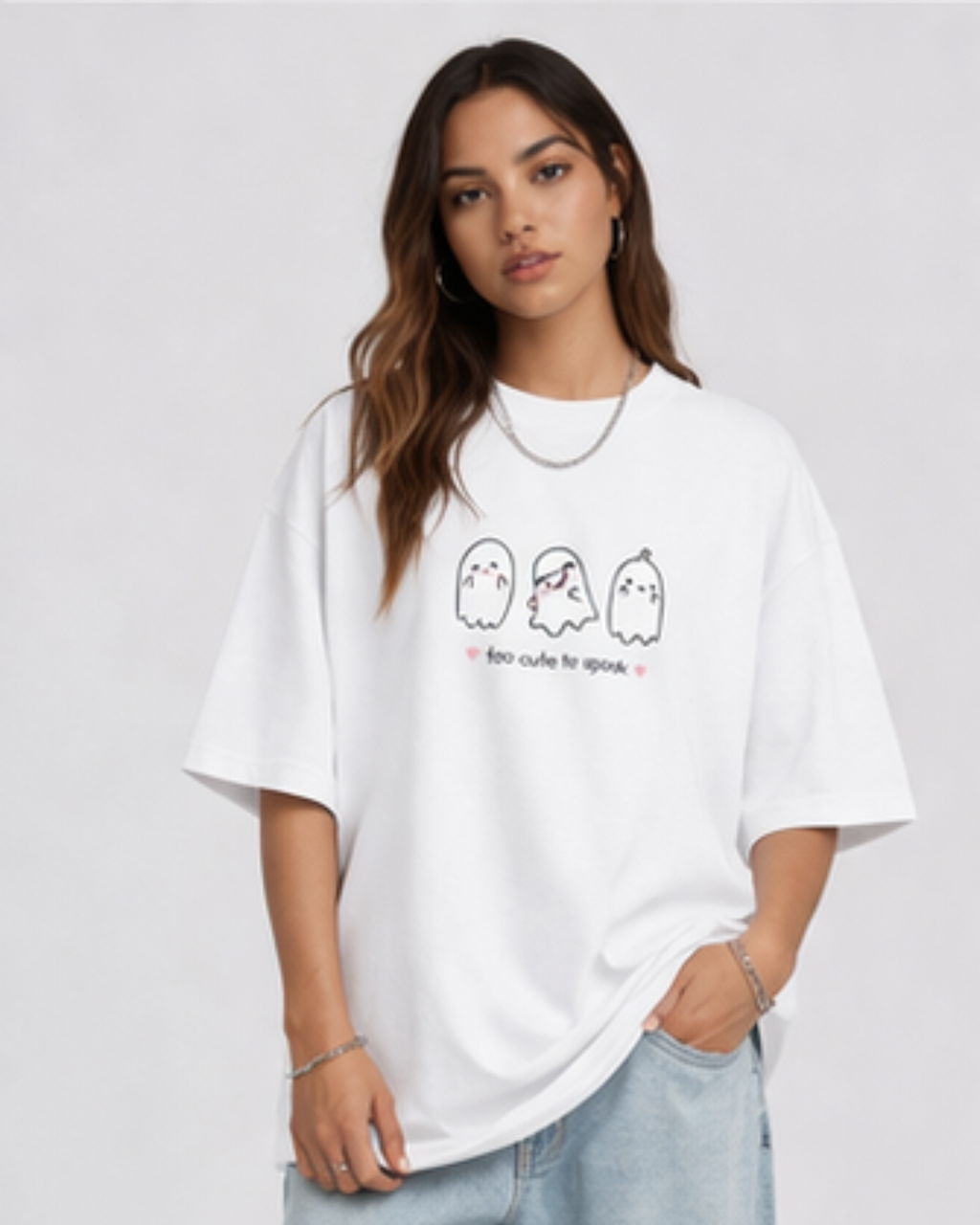 Person wearing a white t-shirt with cartoon ghost designs on a plain background