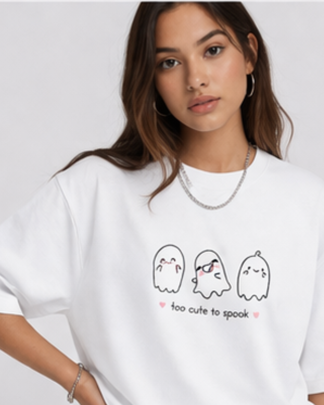 Person wearing a white t-shirt with ghost illustrations and text on a plain background