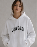 Person wearing a white hoodie with 'UNFOLD' text on a plain background