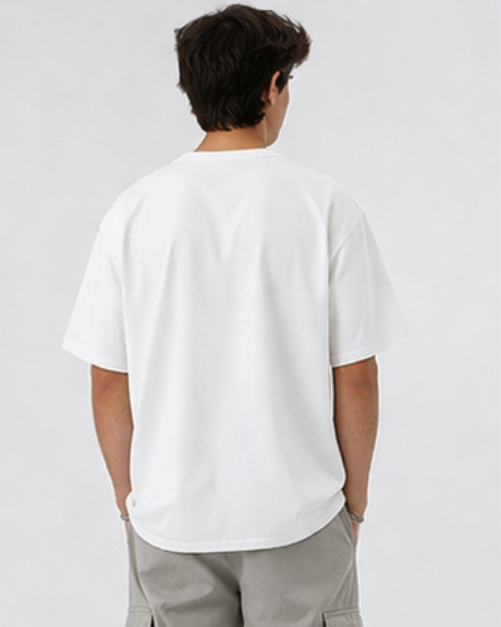 Person wearing a plain white t-shirt and light gray pants on a white background
