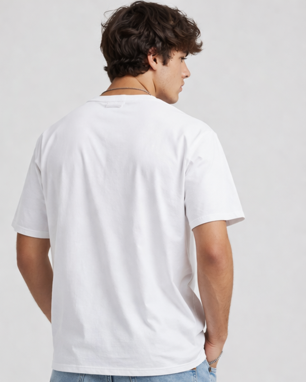 Person wearing a plain white t-shirt on a light gray background