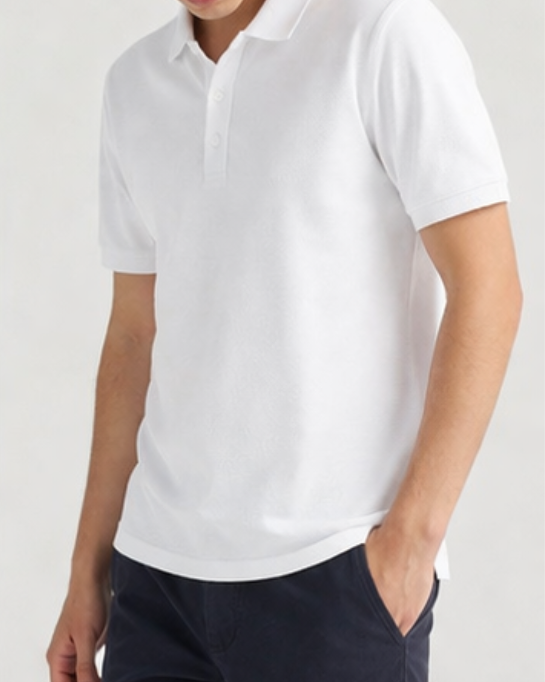 Person wearing a white polo shirt on a plain background