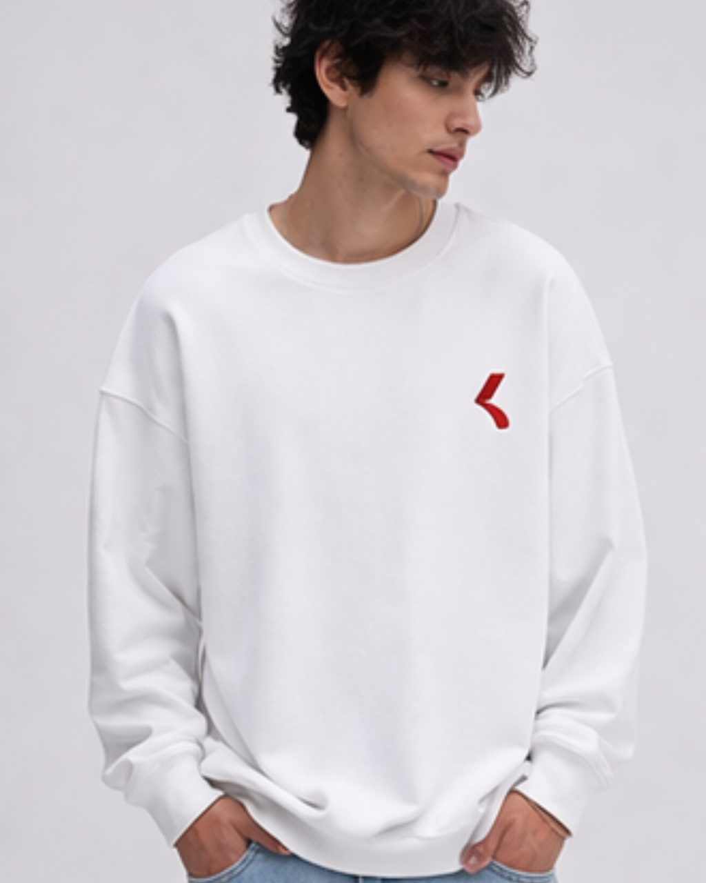 Person wearing a white sweatshirt with a red logo on a light gray background