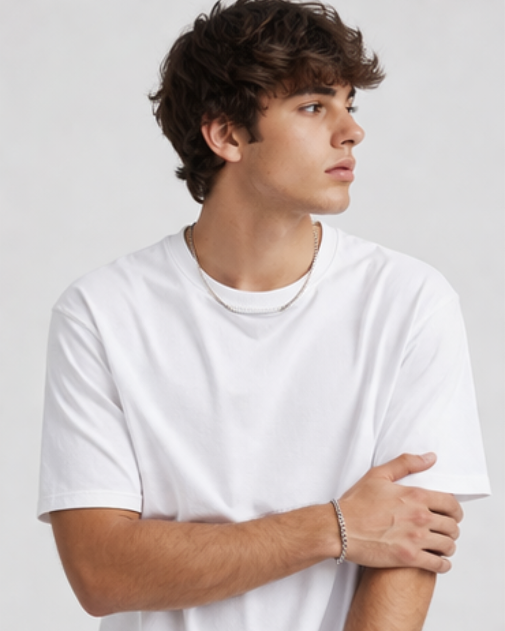 Person wearing a plain white t-shirt against a light gray background